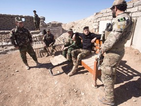 A Canadian special forces soldier, right, speaks with Peshmerga fighters at an observation post, Monday, February 20, 2017 in northern Iraq. A senior representative for Iraq's Kurdistan region is inviting Canada to once again provide training and equipment to Kurdish security forces, who worked shoulder-to-shoulder with Canadian soldiers in the war against the Islamic State group before being frozen out in 2017.