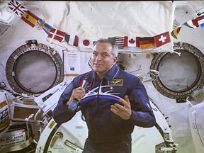 Canadian Space Agency astronaut David Saint-Jacques responds to a question during his last press conference in orbit before returning to Earth on June 24, seen on a giant screen in Saint-Hubert, Que. on Wednesday, June 19, 2019.