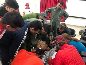 In this handout photo released by the Indo-Tibetan Border Police on June 3, 2019, rescued mountaineers look at a an aerial picture along with rescue personnel upon arriving to a Indo-Tibetan Border Police camp in Pithoragarh, India. (AFP PHOTO / Indo-Tibetan Border Police)