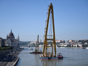 Crews moved a giant floating crane into place near a bridge on the Danube River in Budapest, June 8, 2019. (REUTERS/Tamas Kaszas)