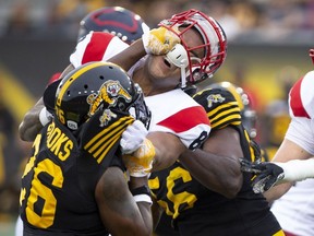 Tiger-Cats defensive back Cariel Brooks gets into the face of Alouettes fullback Spencer Moore during first half Friday night in Hamilton.