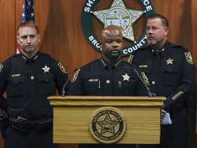 Broward Sheriff Gregory Tony, centre, announces that two additional deputies have been fired as a result of the agency's internal affairs investigation into the mass shooting at Marjory Stoneman Douglas High School in Parkland, Wednesday, June 26, 2019.  (Joe Cavaretta/South Florida Sun-Sentinel via AP)