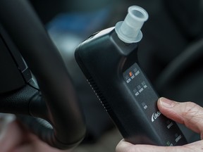 Bill Chastain, State Director with LifeSafer, demonstrates a breath alcohol ignition interlock device during a "Drive Sober or Get Pulled Over" press conference announcing a holiday crack-down on drunk and drugged driving December 17, 2013  in Washington, DC.