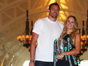 Champion Caroline Wozniacki poses with the Billie Jean King trophy and professional basketball player David Lee after her victory against Venus Williams in the final of the BNP Paribas WTA Finals Singapore presented by SC Global at Clifford Pier on Oct. 30, 2017 in Singapore.  (Clive Brunskill/Getty Images)