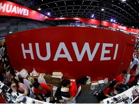 Workers sit a the Huawei stand at the Mobile Expo in Bangkok, Thailand May 31, 2019.