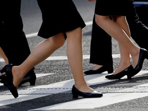 Women in high heels walk at a business district in Tokyo, Japan, June 4, 2019.