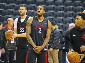 Kawhi Leonard plays spectator as he watches Raptors teammates Marc Gasol (left) and Kyle Lowry work on their shots during yesterday’s shootaround at Scotiabank Arena.