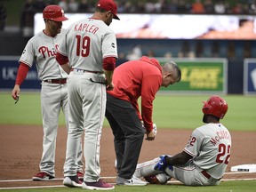 A trainer looks at Andrew McCutchen of the Philadelphia Phillies after he was tagged out during a game against the San Diego Padres at Petco Park June 3, 2019 in San Diego. (Denis Poroy/Getty Images)