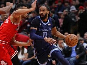 Grizzlies' Mike Conley (right), drives around Bulls' Timothe Luwawu-Cabarrot during NBA action at the United Center in Chicago on Feb. 13, 2019.