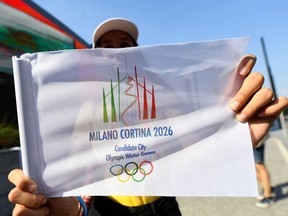 Italians react to the announcement of the host city for the 2026 Winter Olympic Games - Milan, Italy - June 24, 2019   The logo for Milan-Cortina D'Ampezzo 2026 Winter Olympic Games is displayed as Italians celebrate after it was announced as the winning candidate.