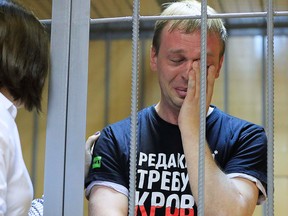 A lawyer comforts Russian investigative journalist Ivan Golunov, who was detained by police and accused of drug offences, during a court hearing in Moscow, Russia June 8, 2019. The writing on the T-shirt reads, "Editorial desk demands blood."