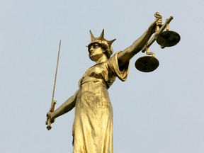 A statue representing the scales of justice is seen on the roof of the Old Bailey courts in central London, January 26, 2007. (REUTERS/Toby Melville/File Photo)