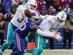 Ryan Tannehill of the Miami Dolphins is hit by Shaq Lawson of the Buffalo Bills and fumbles during NFL action at New Era Field on December 30, 2018 in Buffalo. (Tom Szczerbowski/Getty Images)