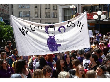 People hold a banner during a day-long and nationwide women's strike aimed at highlighting the country's poor record on defending the rights of women and families in Lausanne, Switzerland, June 14, 2019.