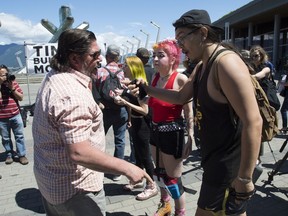 Anti-pipeline protesters, right, argue with a man attending a pro-pipeline gathering in downtown Vancouver, Tuesday, June 18, 2019.