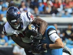 Cody Kessler of the Jacksonville Jaguars is tackled by Jadeveon Clowney of the Houston Texans during the second half at TIAA Bank Field on October 21, 2018 in Jacksonville, Florida.