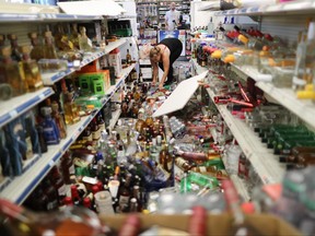 An employee cleans an aisle with toppled bottles scattered on the floor in a convenience store, following a 7.1 magnitude earthquake which struck nearby, on July 6, 2019 in Ridgecrest, Calif. (Mario Tama/Getty Images)