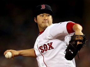 Junichi Tazawa of the Boston Red Sox pitches against the St. Louis Cardinals in the seventh inning of Game Six of the 2013 World Series at Fenway Park on October 30, 2013 in Boston, Massachusetts.