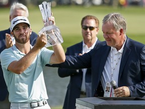 Matthew Wolff takes the trophy from 3M vice-president Jeff Lavers after winning the 3M Championship golf tournament at TPC Twin Cities. (Bruce Kluckhohn-USA TODAY Sports)