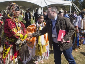 Dancer Kevin Haywahe, left, shakes hands with Alberta Premier Jason Kenney during a welcoming event outside the Sgt. Darby Morin Centre in Big River on July 9, 2019.