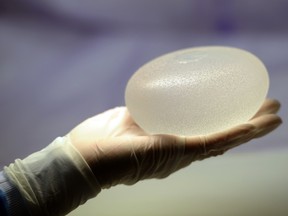 This file picture taken on January 12, 2012 in Boissy-l'Aillerie, northern Paris, shows a technician presenting a silicone breast implant. (MIGUEL MEDINA/AFP/Getty Images)