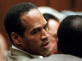 In this file photo taken on February 15, 1995, double murder defendant OJ Simpson talks to attorney Johnnie Cochran Jr., during testimony by a Los Angeles Detective Ron Phillips.