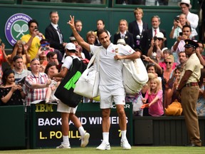 Switzerland's Roger Federer waves as he leaves the court after beating France's Lucas Pouille, left,  during their men's singles third round match on the sixth day of the 2019 Wimbledon Championships at The All England Lawn Tennis Club in Wimbledon, southwest London, on July 6, 2019. (GLYN KIRK/AFP/Getty Images)