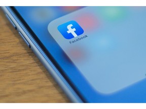 The Facebook logo is seen on a phone in this photo illustration in Washington, DC, on July 10, 2019.