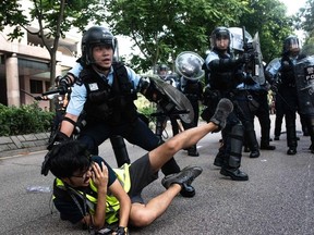 A photojournalist falls down during clashes between protesters and police at an anti parallel trading march in Sheung Shui district in Hong Kong on July 13, 2019.