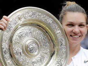 Romania's Simona Halep poses with the Venus Rosewater Dish trophy after beating US player Serena Williams during their women's singles final on day twelve of the 2019 Wimbledon Championships at The All England Lawn Tennis Club in Wimbledon, southwest London, on July 13, 2019.