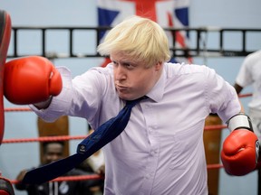 In this file photo taken on October 28, 2014 Mayor of London Boris Johnson boxes with a trainer during his visit to Fight for Peace Academy in North Woolwich, London. - Former London mayor Boris Johnson on July 23, 2019 won the race to become Britain's next prime minister, defeating Foreign Secretary Jeremy Hunt in the Conservative Party leadership contest. (LEON NEAL/Getty Images)