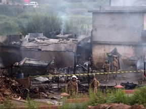 Military personnel work at the scene where a Pakistani Army Aviation Corps aircraft crashed in Rawalpindi on July 30, 2019. (AAMIR QURESHI/AFP/Getty Images)