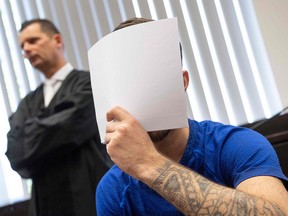 Ali Bashar covers his face in front of the cameras upon entering the courtroom, as his lawyer Martin Reineke looks on, on July 10, 2019 in Wiesbaden, Germany. (BORIS ROESSLER/AFP/Getty Images)