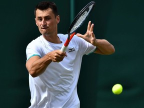 Australia's Bernard Tomic returns the ball to France's Jo-Wilfried Tsonga during their men's singles first round match of the Wimbledon Championships at The All England Lawn Tennis Club in Wimbledon, southwest London, on Tuesday, July 2, 2019.