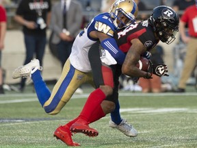 Winnipeg Blue Bombers defensive back Chandler Fenner (left) tackles Ottawa Redblacks wide receiver R.J. Harris during their game last night at TD Place in Ottawa.