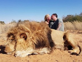 Darren and Carolyn Carter posing as they kiss over the dead lion they killed on safari.