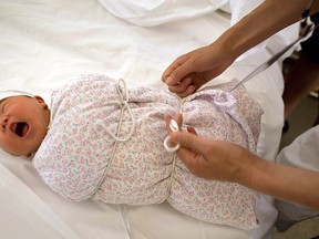 A nurse wraps up a baby boy who was born in Dujiangyan, Sichuan province, China. (Andrew Wong/Getty Images)