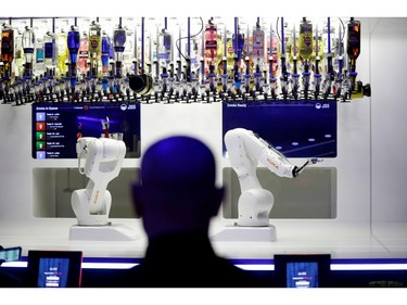 A customer looks at a robotic bartender preparing a drink in Karlovy Lazne Music Club in Prague, Czech Republic, July 18, 2019.