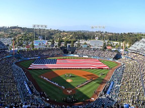 Members of the military hold an American flag on the field before the game between the Los Angeles Dodgers and the San Diego Padres at Dodger Stadium on July 4, 2019 in Los Angeles. (Jayne Kamin-Oncea/Getty Images)