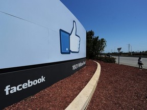 A woman shoots video of the Facebook sign at the entrance to the company's main campus in Menlo Park, Calif, on May 15, 2012.