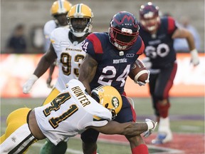 Alouettes running-back Jeremiah Johnson breaks away from Eskimos' Monshadrik Hunter during CFL action in July.