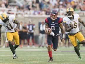 Montreal Alouettes quarterback Vernon Adams Jr. breaks away from Edmonton Eskimos' Larry Dean and Mike Moore during second half CFL football action in Montreal, Saturday, July 20, 2019.