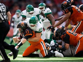 Saskatchewan Roughriders defensive tackle Zack Evans (92) sacks B.C. Lions Mike Reilly (13) in the first half of Saturday's game at BC Place.