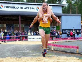 Vytautas Kirkliauskas of Lithuania carries his wife Neringa Kirkliauskiene as they compete during the Wife Carrying World Championships in Sonkajarvi, Finland, July 6, 2019.