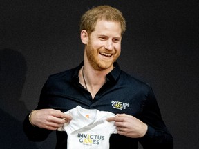 Prince Harry, Duke of Sussex is presented with an Invictus Games baby grow for his newborn son Archie by Princess Margriet of The Netherlands during the launch of the Invictus Games on May 9, 2019 in The Hague, Netherlands.  Patrick van Katwijk/Getty Images