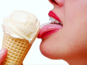 Close-up female lips with red lipstick eating a vanilla ice cream cone