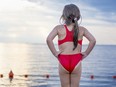 A little Caucasian girl on the platform before jumping into the sea