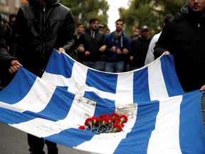 Athens' Polytechnic school students carry a blood-stained Greek flag during a rally marking the 45th anniversary of a 1973 student uprising against the military dictatorship that was ruling Greece, in Athens, Greece, November 17, 2018. (REUTERS/Costas Baltas/File Photo)