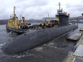 The crew members from HMCS Chicoutimi work on deck as they slip from the jetty at Faslane, Scotland.  (Postmedia file photo)