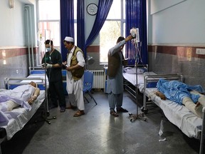 Afghan men receive treatment at a hospital after a bus was hit by a roadside bomb in Herat province, western Afghanistan July 31, 2019.